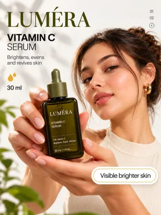 Woman posing beside a Lumera Vitamin C serum bottle and fresh orange slices under warm gold Glow lettering.